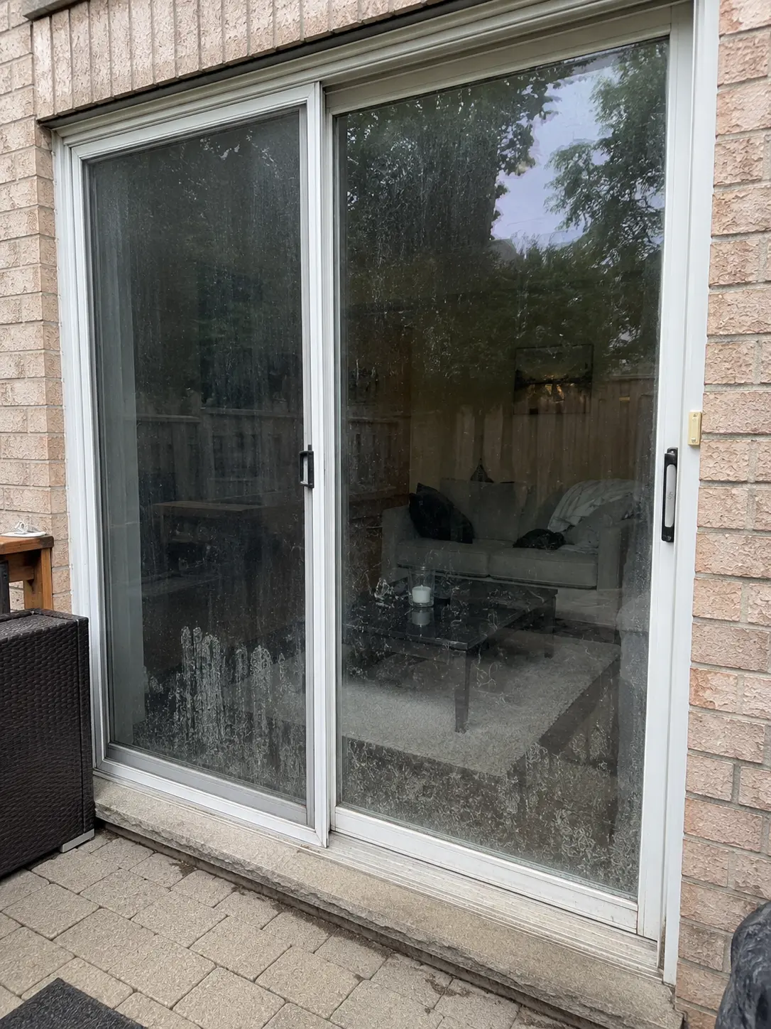 Patio glass door with heavy water spotting before exterior window cleaning