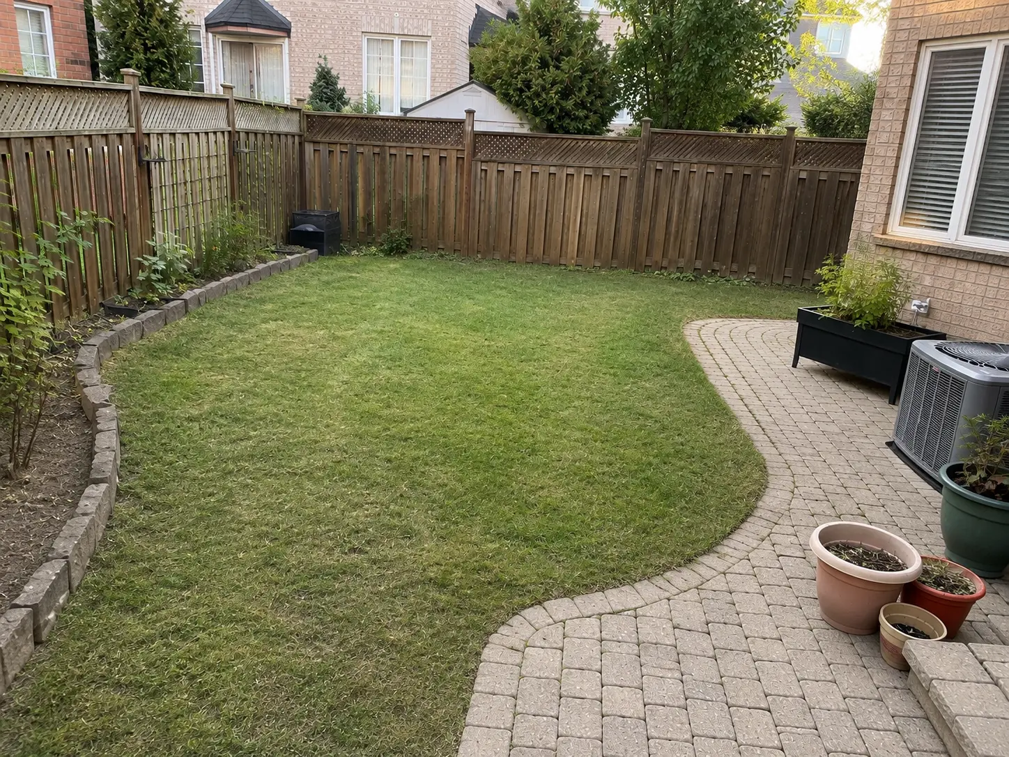 Backyard with tidy beds and a clean patio after property cleanup