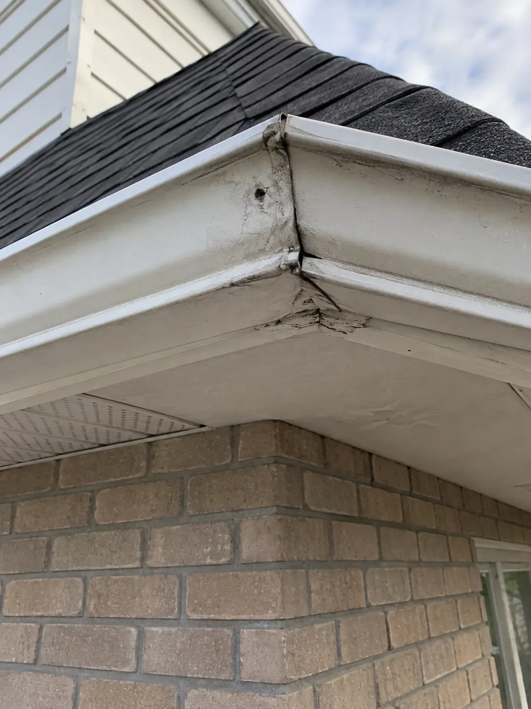 Leaking and stained eavestrough corner seam before repair