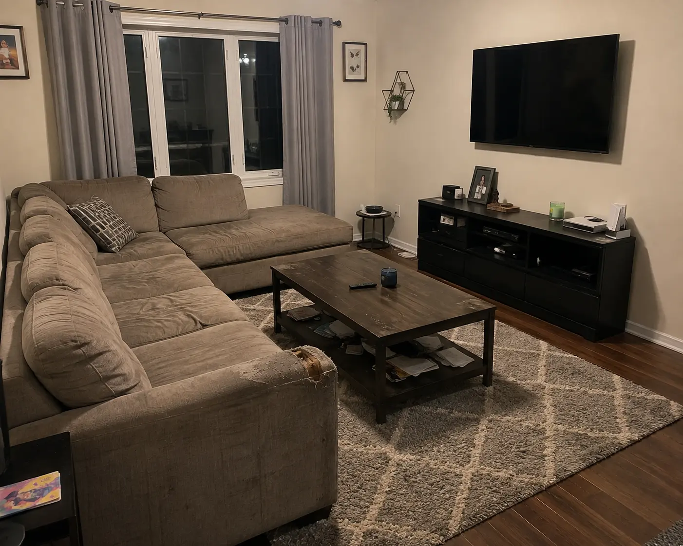 Living room with a worn sectional sofa before furniture removal